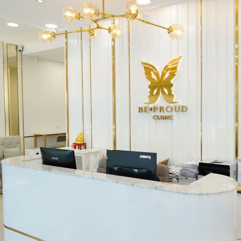 เคาน์เตอร์ต้อนรับของบีพราวด์คลินิก ปัจจุบัน พร้อมโลโก้ผีเสื้อสีทองด้านหลัง